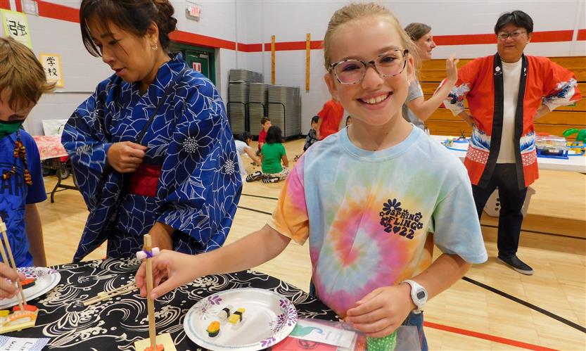 A girl wearing a tie-dye shirt smiles